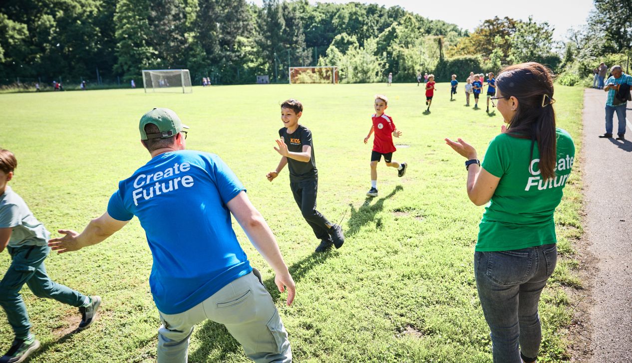 Mitarbeiter:innen feuern Kinder beim laufen bei einem der Laufwunder 25 an
