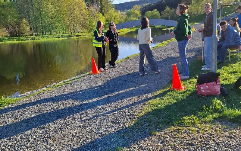 Es sind ein Schotterweg, Leitkegel und Helfer*innen bei einem LaufWunder zu sehen. Im Hintergrund ist ein Teich.