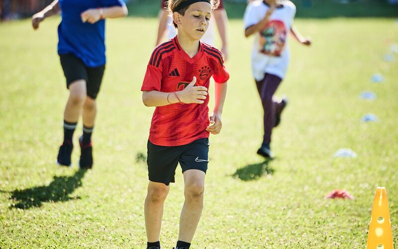 Ein Junge im Sportgewand läuft beim LaufWunder. Dahinter sind weitere laufenden Kinder zu sehen.