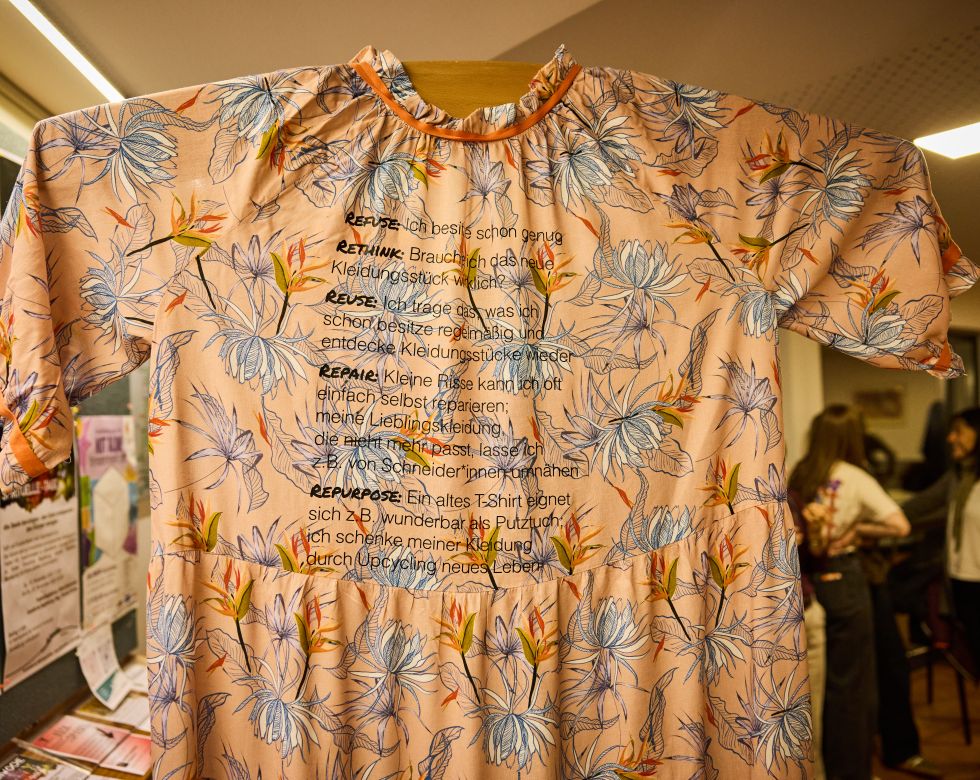 Ein Kleid mit Blumenmuster und Anweisungen zur Wiederverwendung, Reparatur und Upcycling von Kleidung.