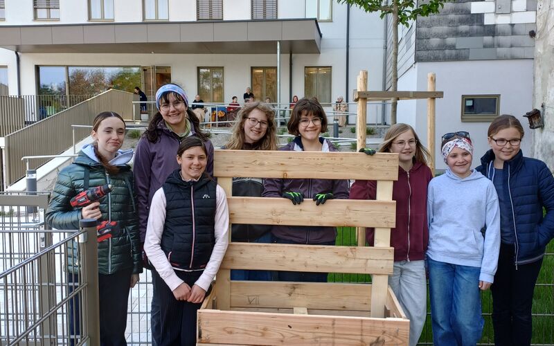 Schüler*innen rund um das fertig aufgebaute Beet