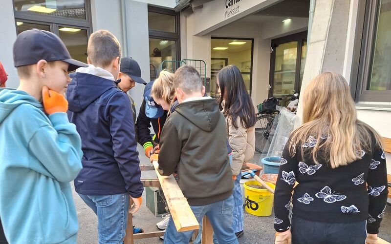 Schüler*innen beim Holzbearbeiten für das Beet.