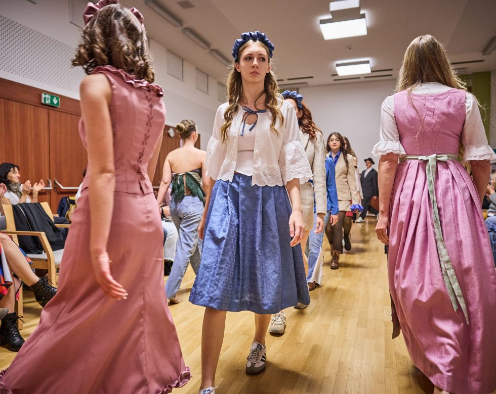 junge Frauen präsentieren ihre selbst entworfenen Kleidungsstücke bei einer Modenschau